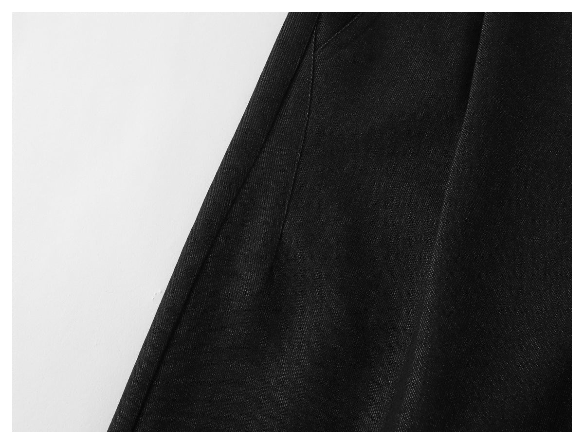 Close-up of black trouser fabric and a vertical seam.