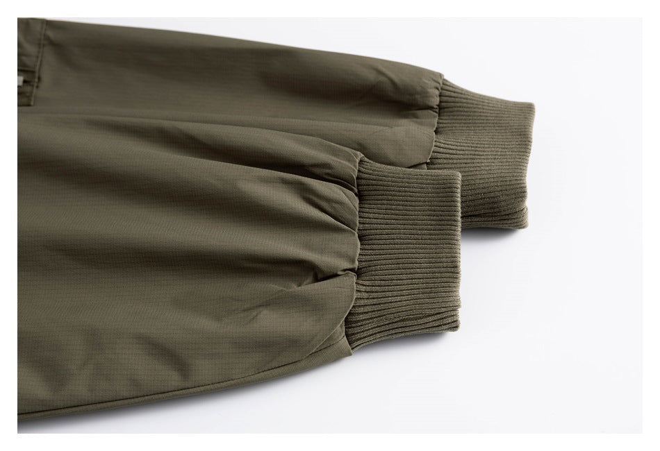 Close-up of the olive jacket’s ribbed knit cuffs and gathered sleeve ends.