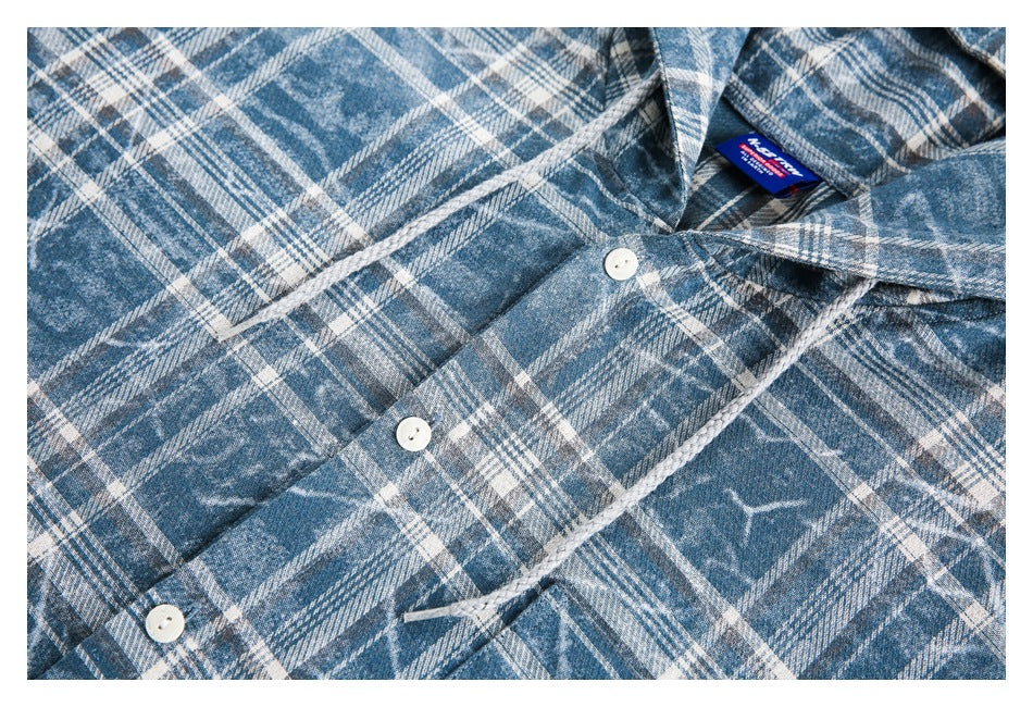 Close-up of the blue-and-white plaid shirt's button-front placket, collar, and sewn-in neck label.