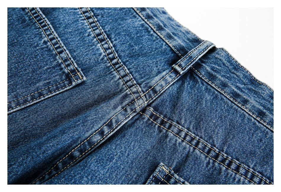 Close-up of blue jeans waistband, belt loop, pocket edge and contrast seams.