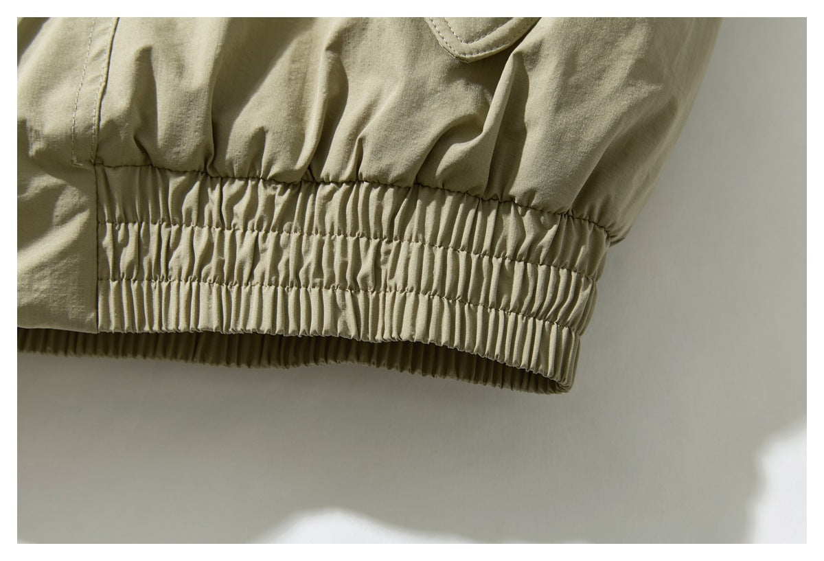 Close-up of the jacket’s gathered elastic hem in olive khaki.