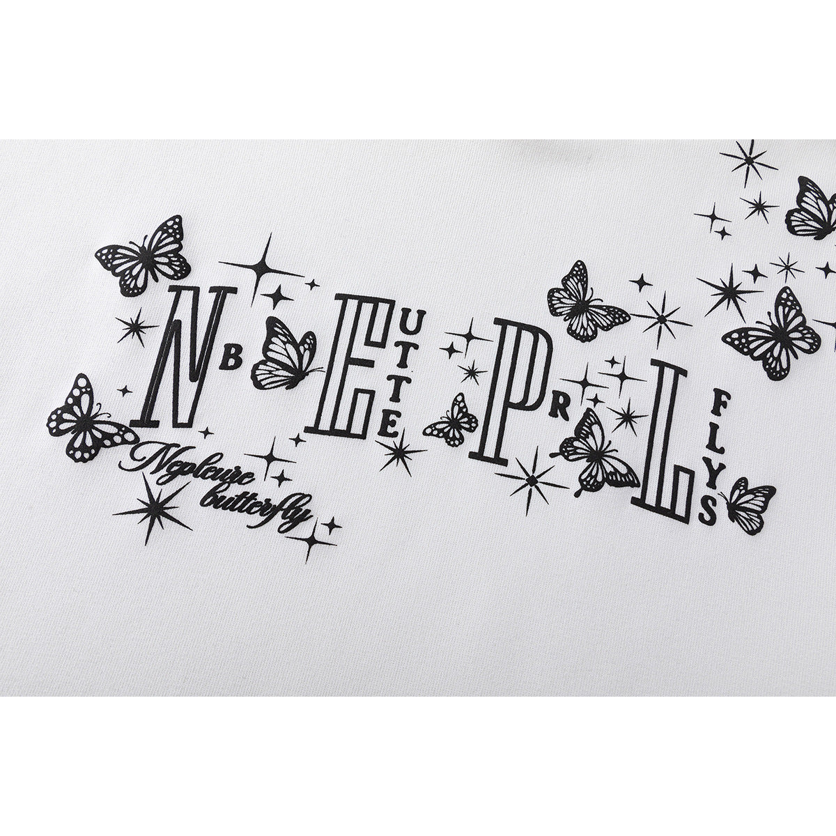 Close-up of black decorative lettering, butterflies, and star motifs printed on white sweatshirt fabric.