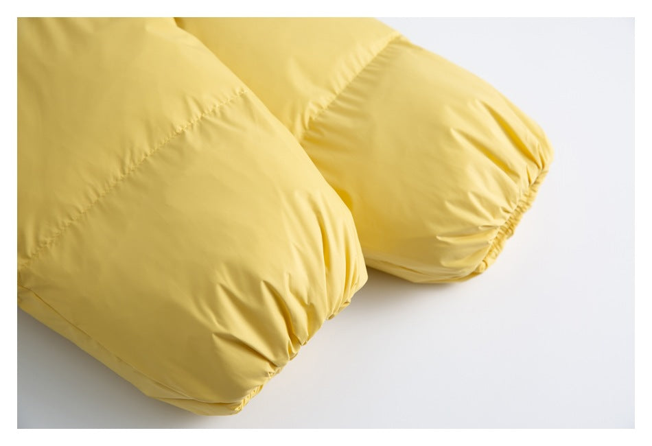 Close-up of the gathered cuffs on the sleeves of a yellow jacket.