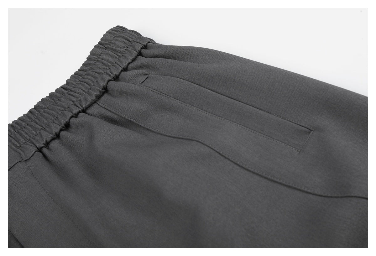 Close-up of charcoal shorts showing a narrow rear pocket and gathered elastic waistband.