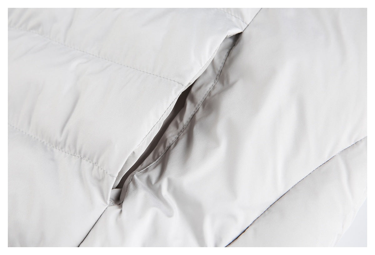 Close-up of a light gray padded garment showing stitched panels and an overlapping seam.