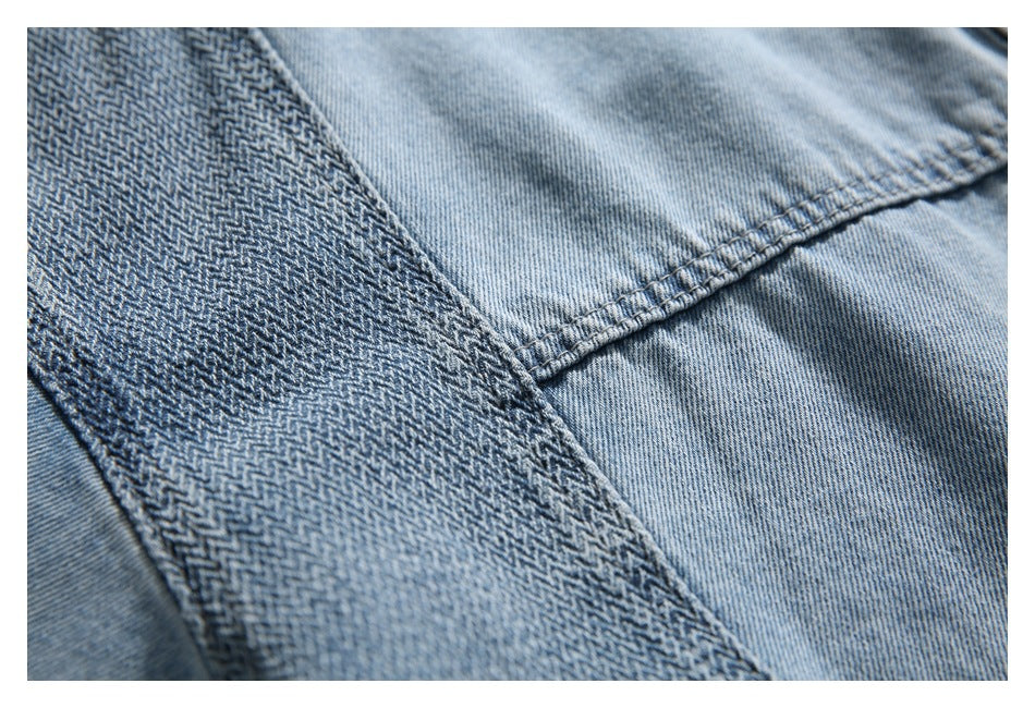 Close-up of light and dark blue denim panels joined by a curved stitched seam.