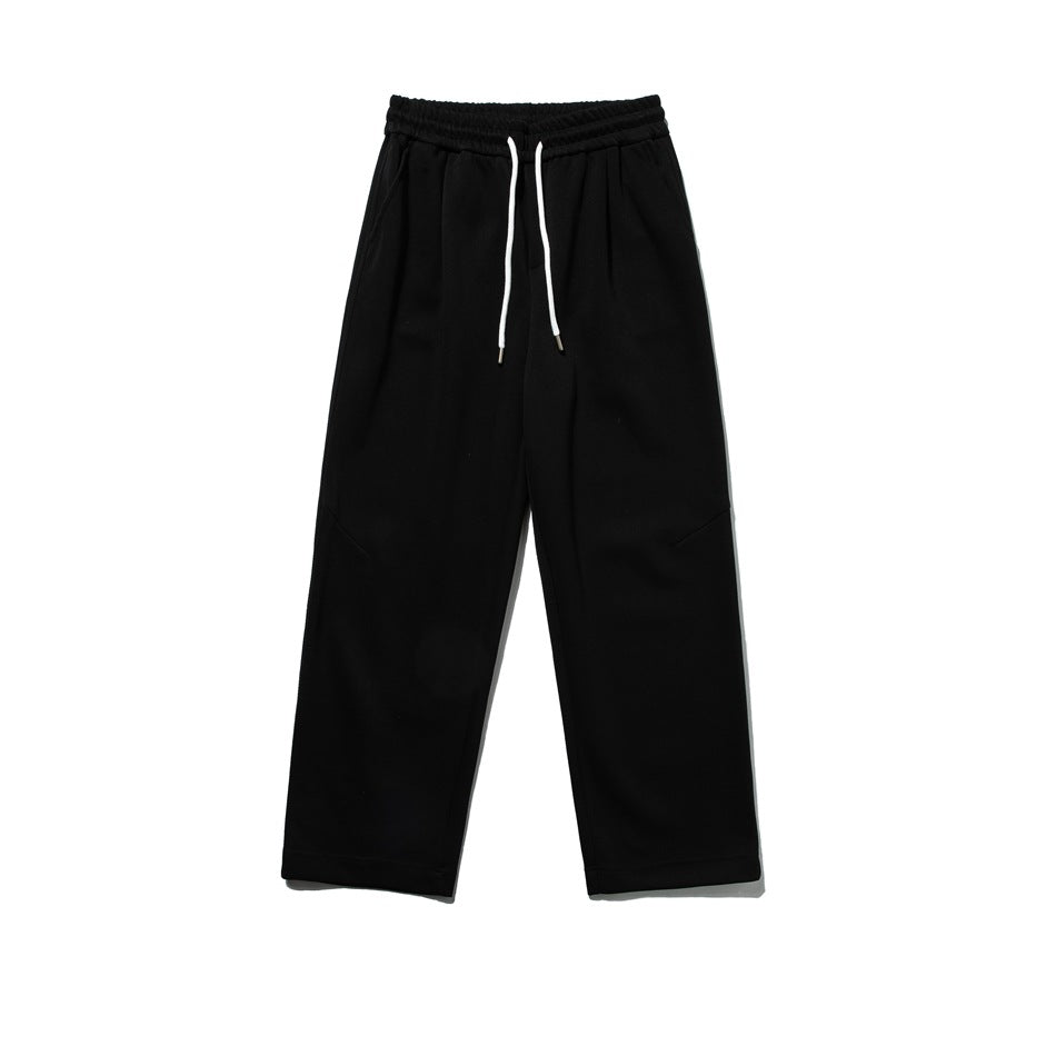 Black straight-leg sweatpants with white drawstring and diagonal knee seams, flat lay front view