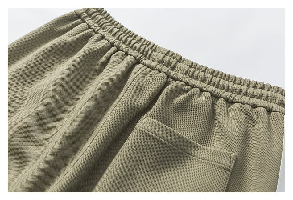 Close-up of olive-gray pants showing the elastic waistband and a back pocket.