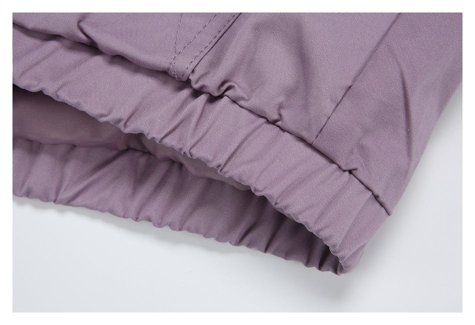 Close-up of a gathered elastic edge and stitching on a muted lavender garment.