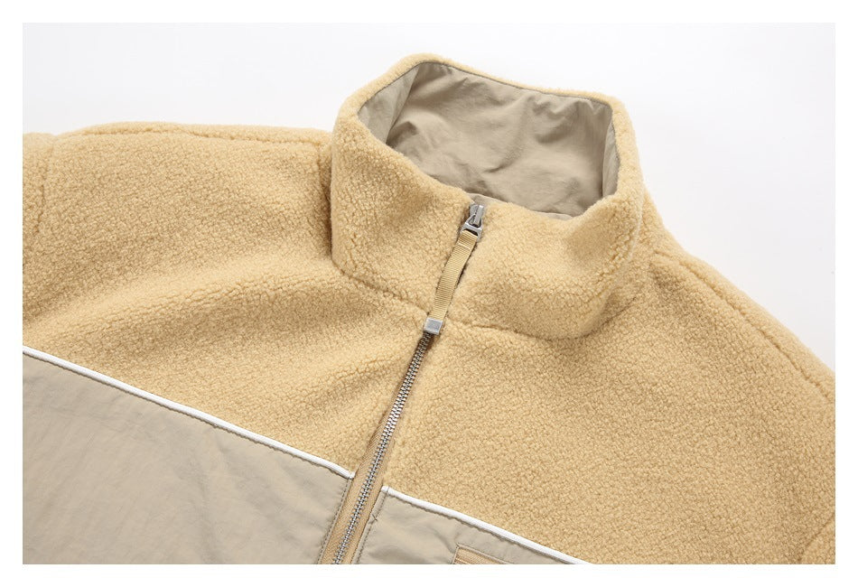 Close-up of a tan fleece jacket's high collar, gray lining, front zipper, and contrasting chest panel.