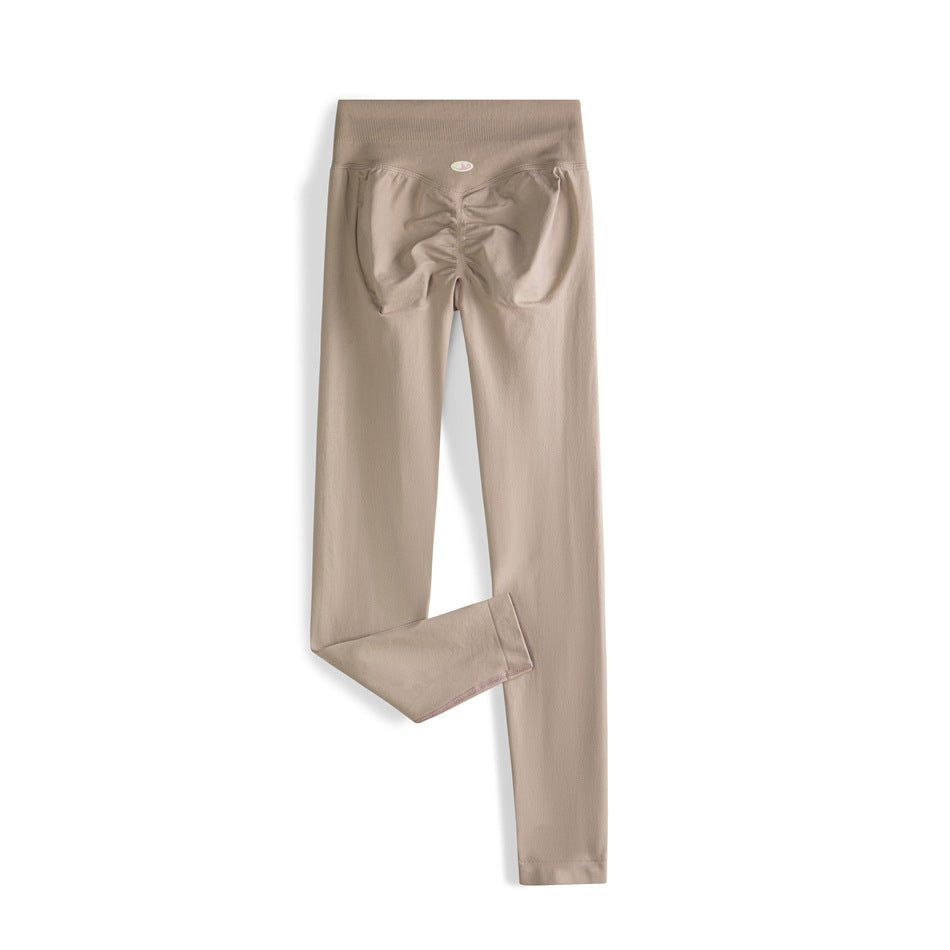 Taupe high-waisted leggings shown from the back, with a ruched seat and one leg folded to show the hem.