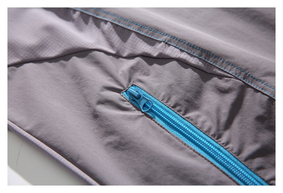 Close-up of the bright blue zipper and stitching on the gray shirt's pocket.