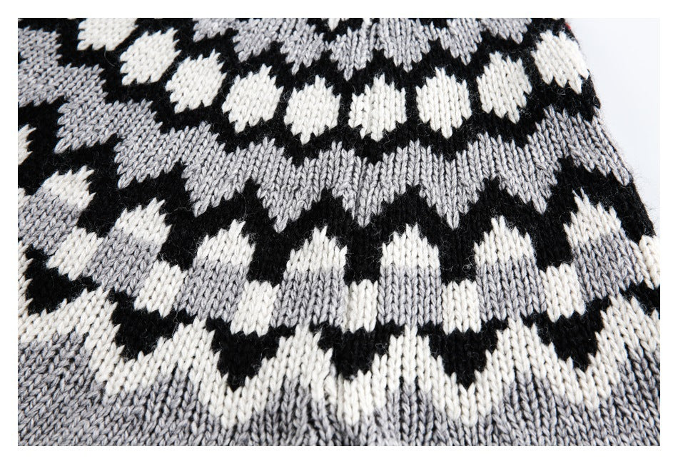 Close-up of repeating black, gray, and cream geometric motifs knitted into the sweater.