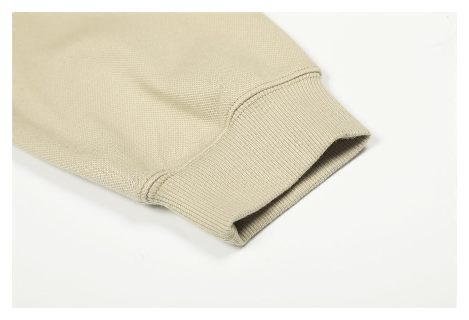 Close-up of a beige sleeve ending in a wide ribbed cuff.