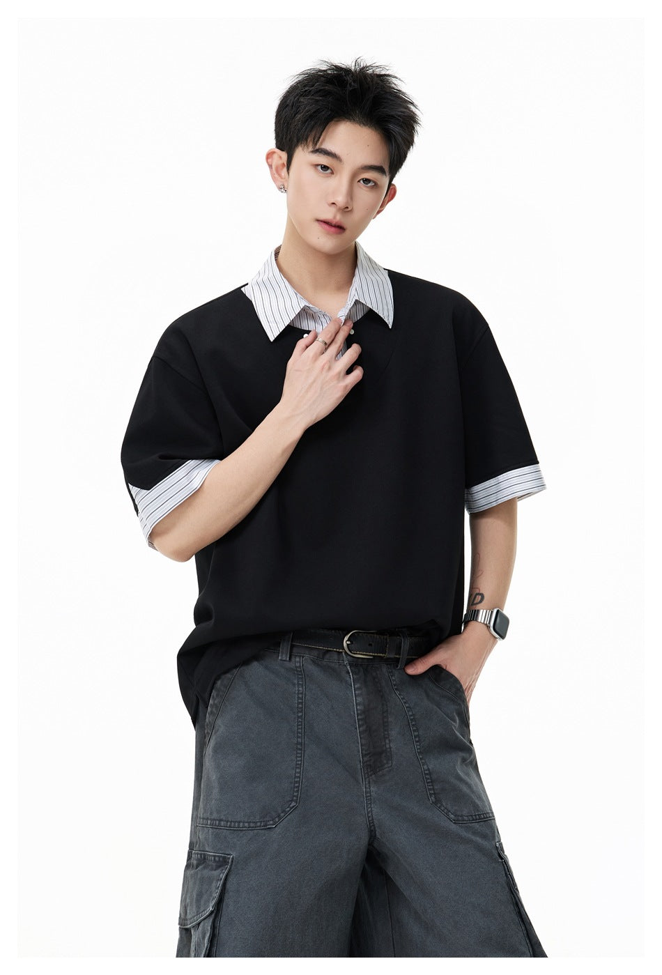 Model wearing a black oversized top with a striped collar and cuffs, paired with charcoal cargo pants.