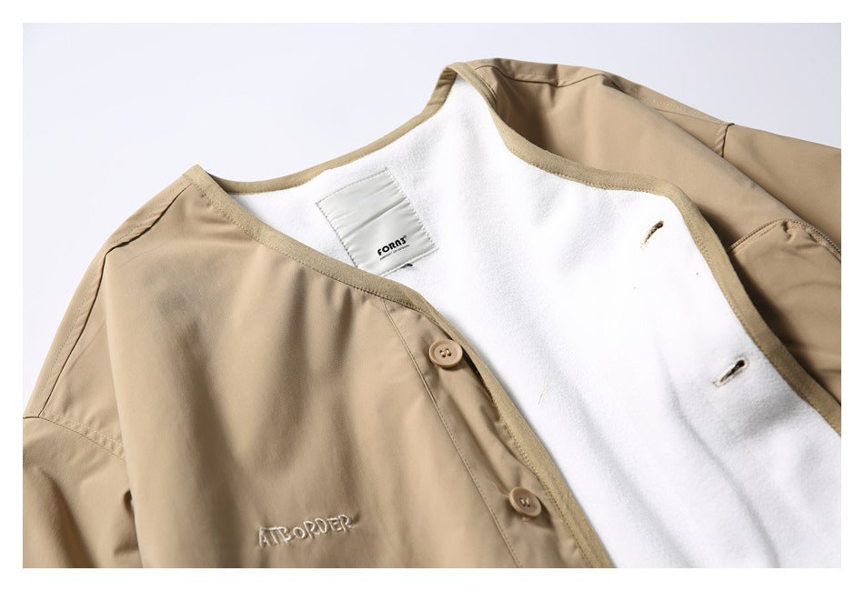 Close-up of the tan jacket’s collar, white lining, neck label, buttons, and chest embroidery.