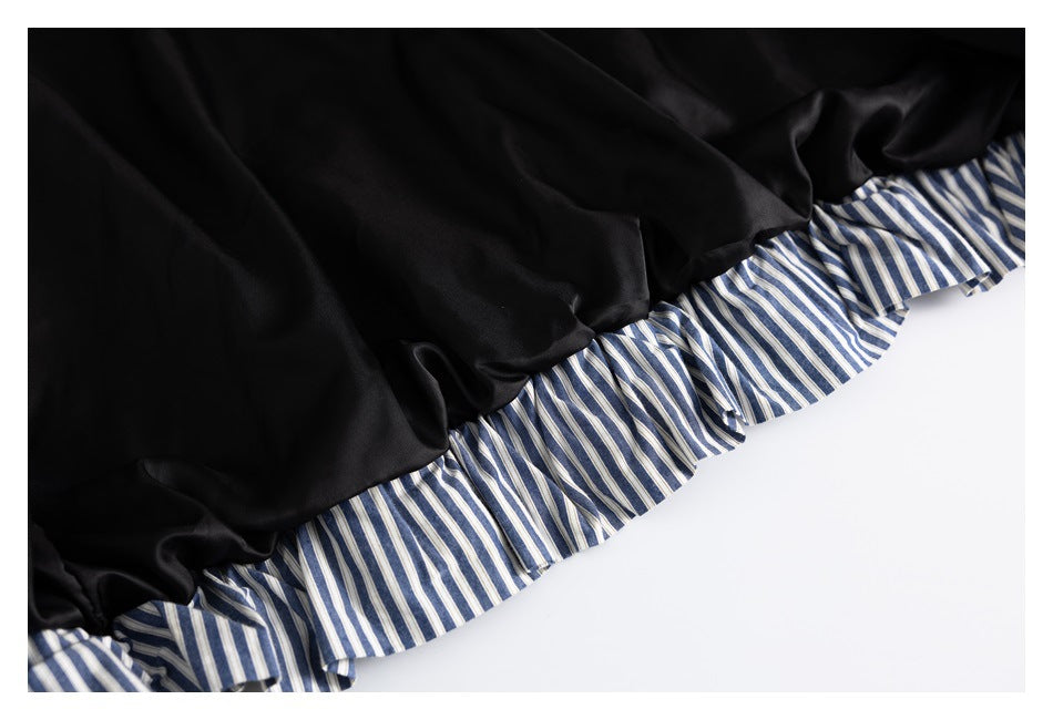 Close-up of black jacket lining finished with a blue-and-white striped ruffle edge.
