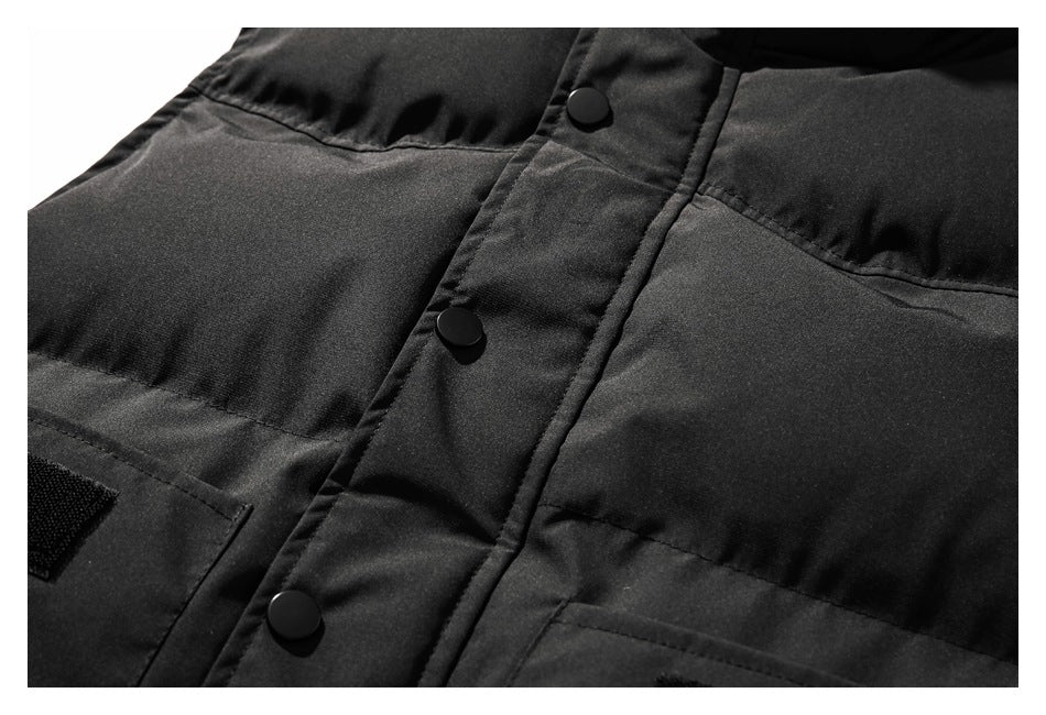 Close-up of a black jacket’s snap-button placket and horizontal stitched panels.