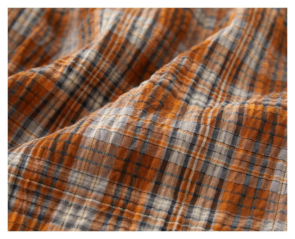 Close-up showing the orange, gray, and cream plaid pattern and textured fabric surface.