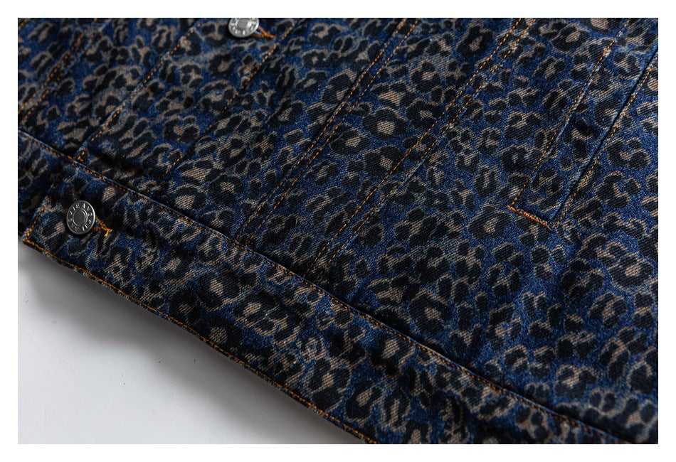 Close-up of leopard-print denim showing panel seams, orange topstitching and silver buttons.