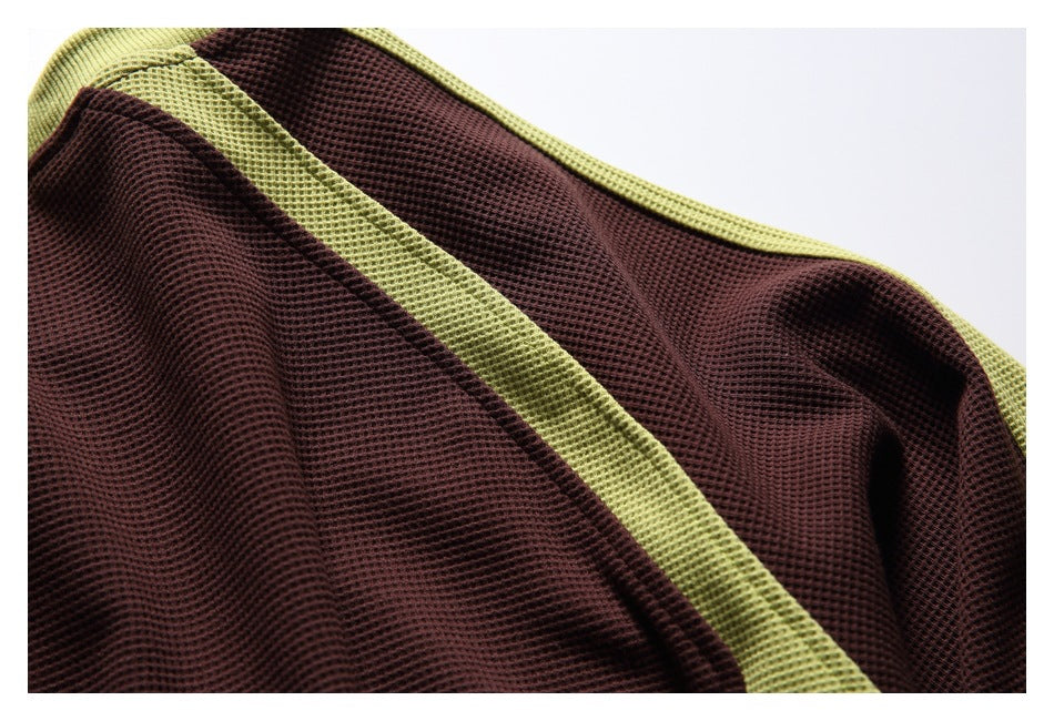 Close-up of dark brown textured fabric with a wide lime-green trim.