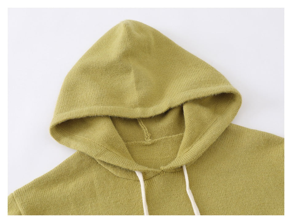 Close-up of a pale yellow-green knit hood and neckline with white drawstrings.