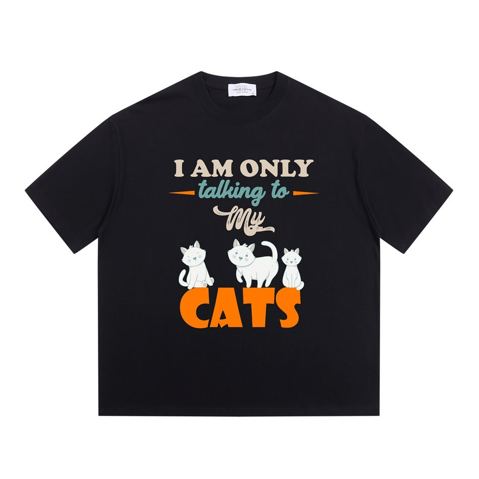 Black short-sleeve crew-neck T-shirt with 'I AM ONLY talking to My CATS' graphic and three cartoon cats, flat lay