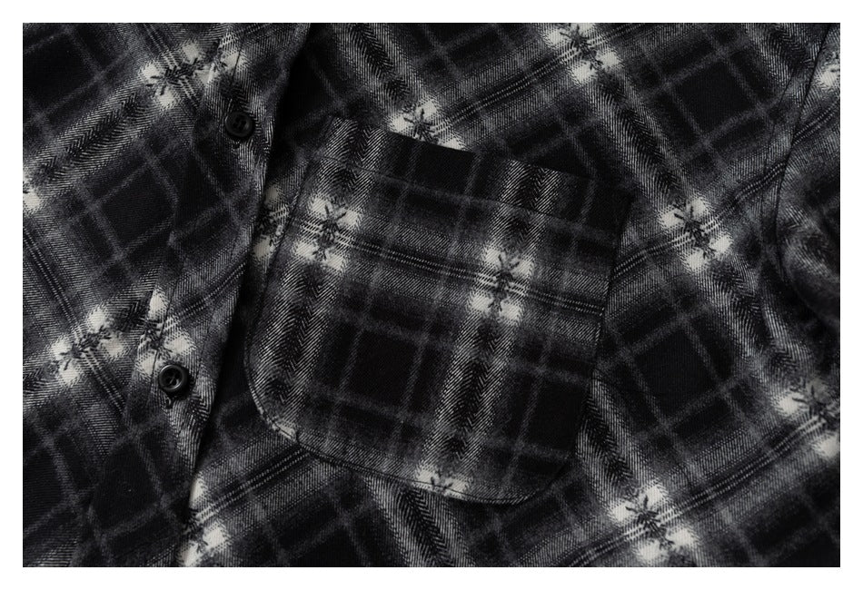 Close-up of the shirt's plaid chest pocket and adjacent black buttons.