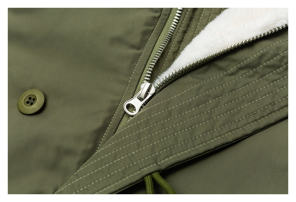 Close-up of an olive jacket's metal zipper, button, and soft white lining.