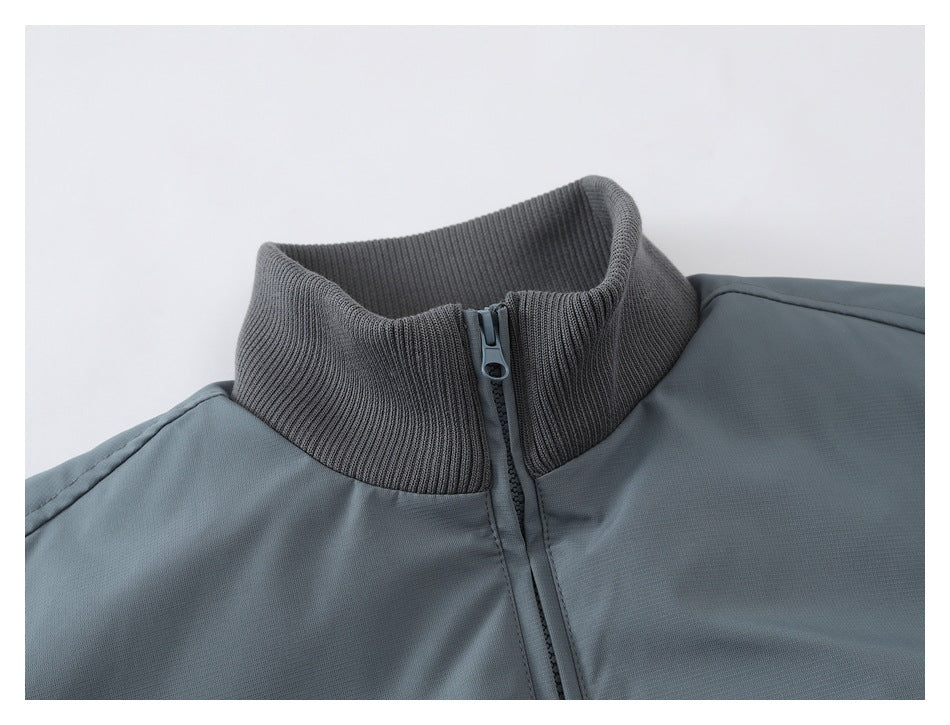 Close-up of a slate blue-gray jacket's dark ribbed stand collar and center zipper.