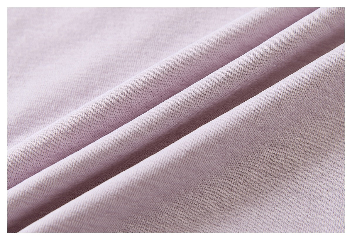 Close-up of pale mauve knit fabric draped in soft folds, showing its fine textured surface.