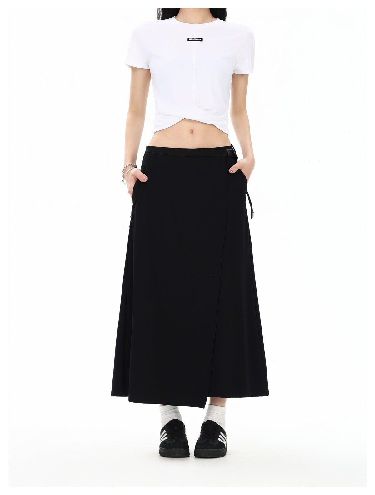Front view of a model wearing a black ankle-length wrap skirt with a side strap and a white cropped T-shirt.