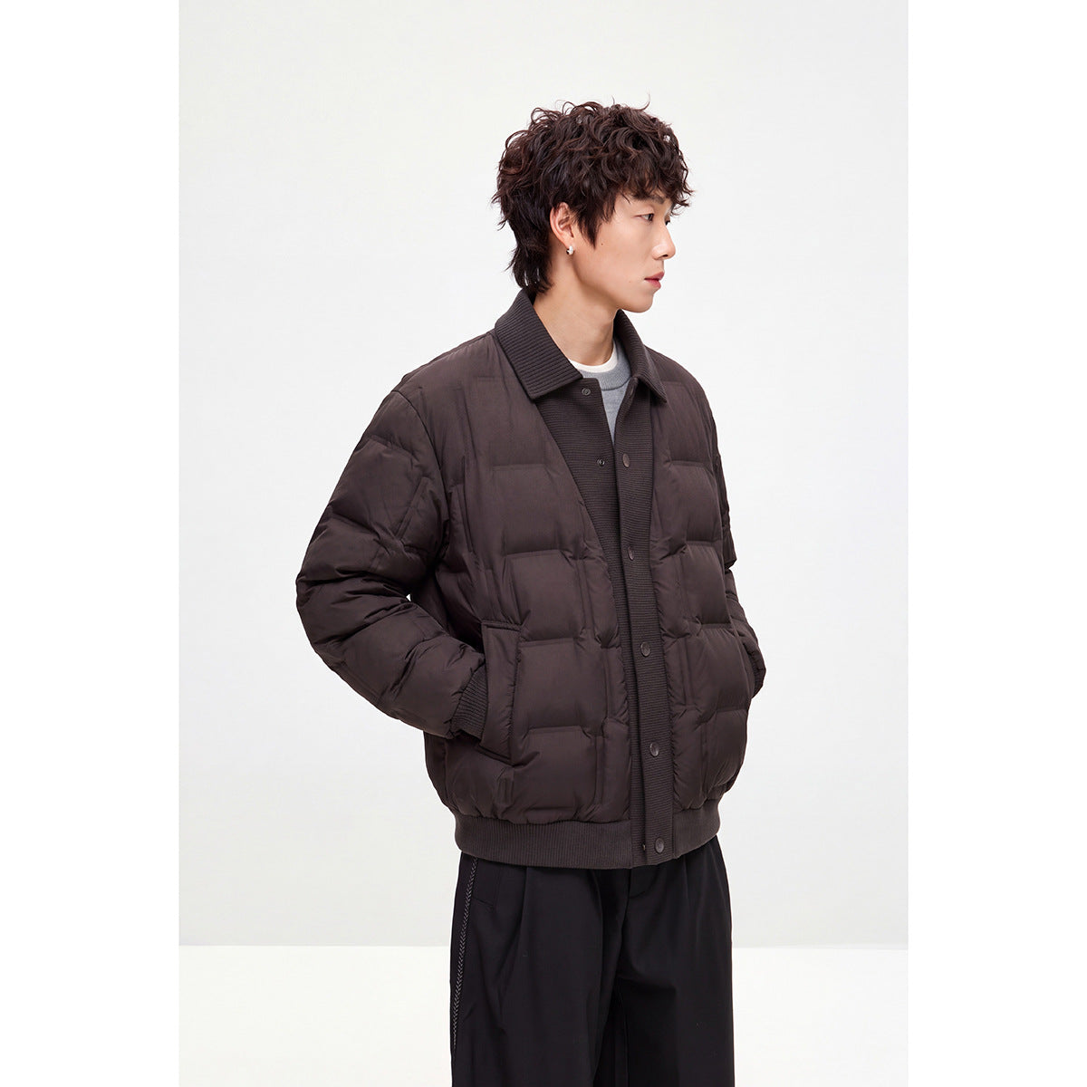 Model wearing a dark brown quilted jacket with a ribbed collar, snap front, and ribbed cuffs and hem.