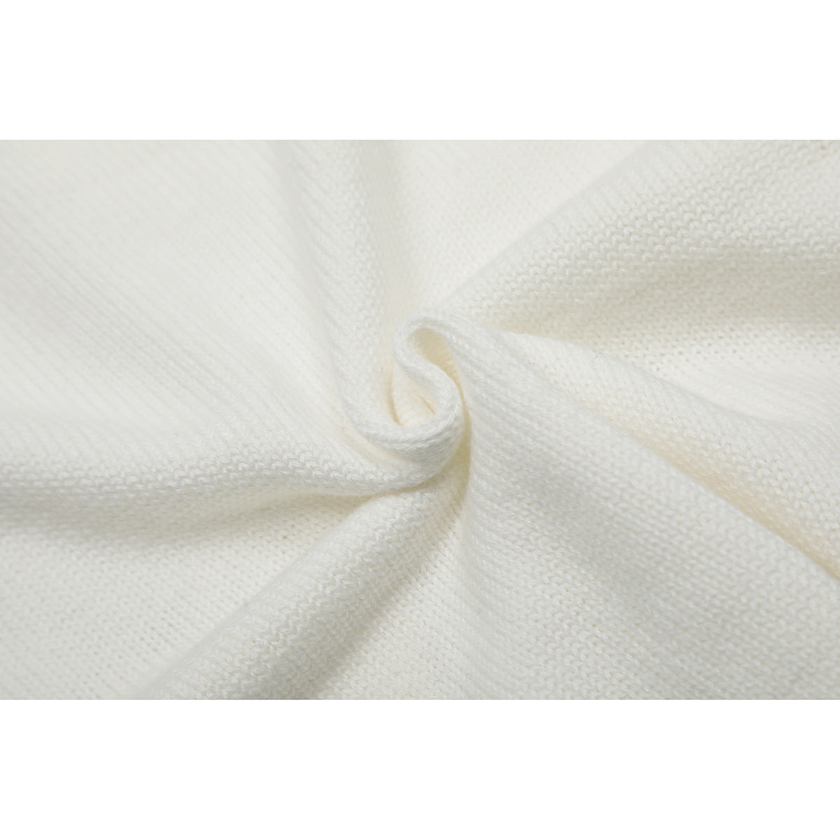 Close-up of folded white knitted fabric showing its stitch texture.