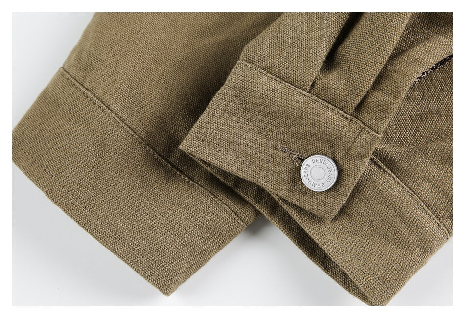 Close-up of a khaki jacket cuff with a silver button and stitched edges.
