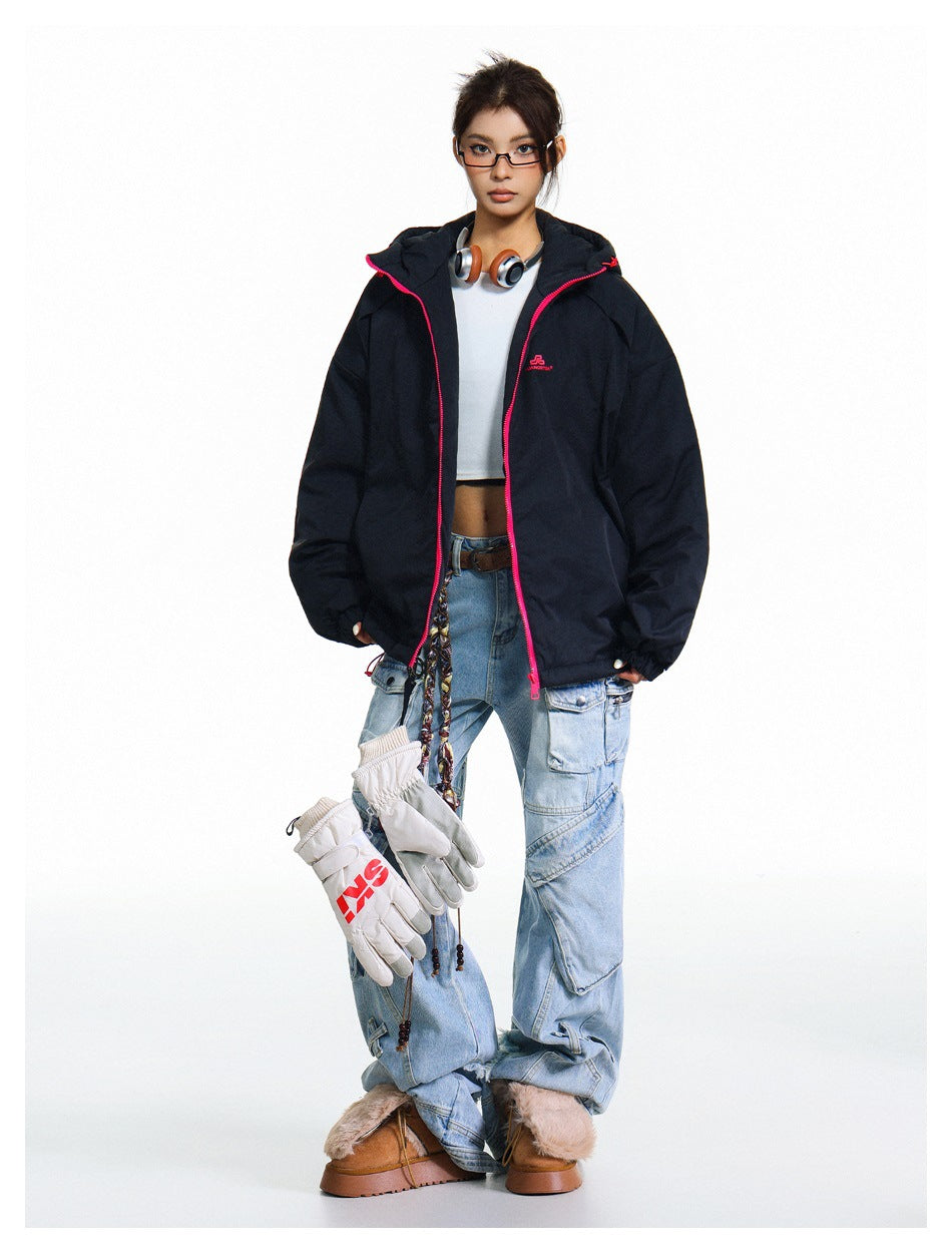 Full-length view of a model in a black hooded jacket with pink zipper, white crop top, light-wash cargo jeans and boots