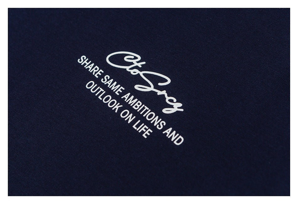 Close-up of white script and slogan printed on navy shirt fabric.