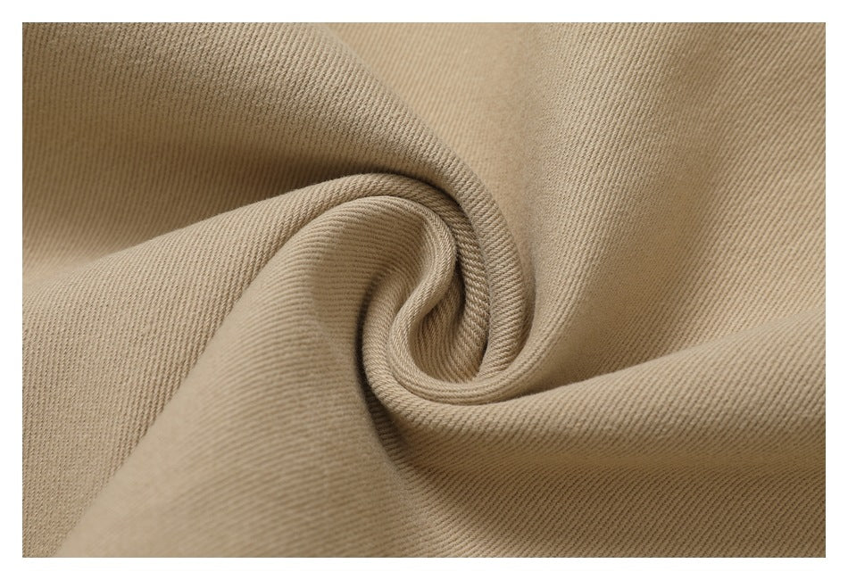 Extreme close-up of the beige pants fabric gathered to show its texture.