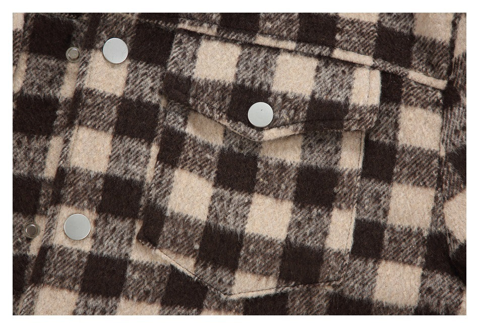 Close-up of a flap pocket and silver snaps on the jacket's brown and beige check pattern.