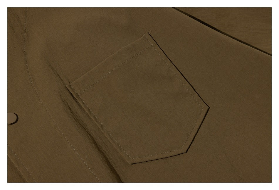 Close-up of a large angular patch pocket stitched onto olive-brown fabric.