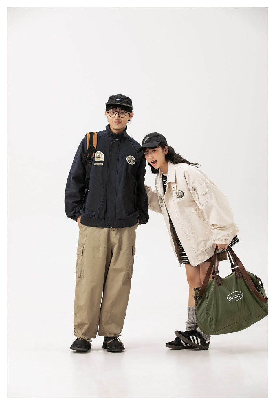 Two models wear a navy jacket and an ivory jacket; the man pairs his with khaki cargo pants.