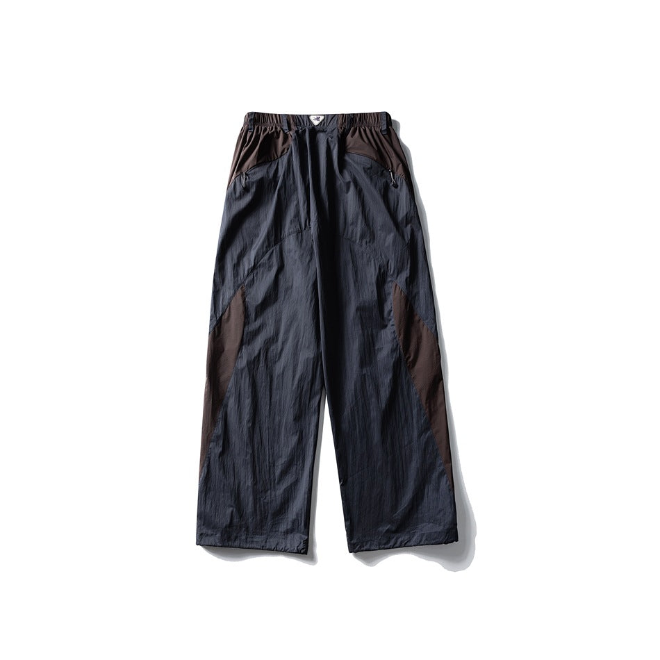 Back view of charcoal wide-leg trousers with brown contrast panels and an elastic waist.