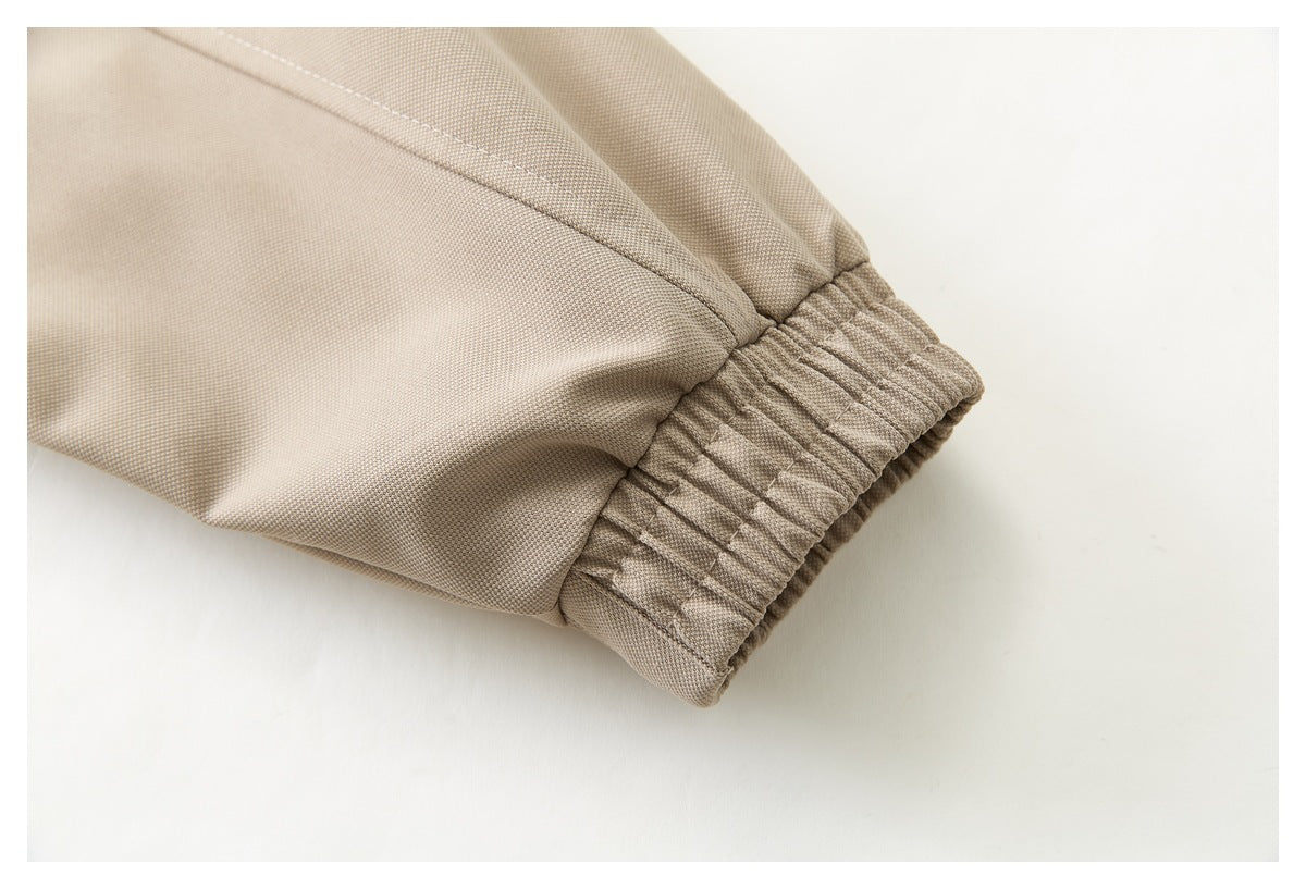 Close-up of a beige jacket sleeve ending in a gathered elastic cuff.