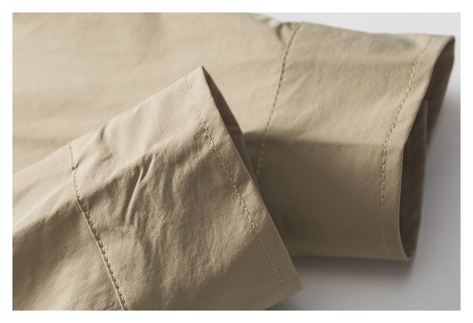Close-up of a light tan garment sleeve cuff with visible stitching.
