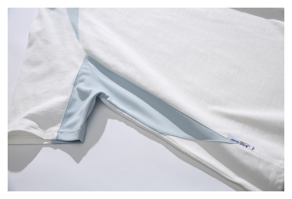 Close-up of the white T-shirt's underarm seam and pale blue mesh side panel.