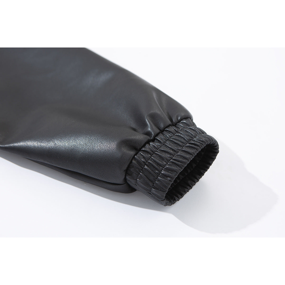 Close-up of a black jacket sleeve ending in a gathered elastic cuff.