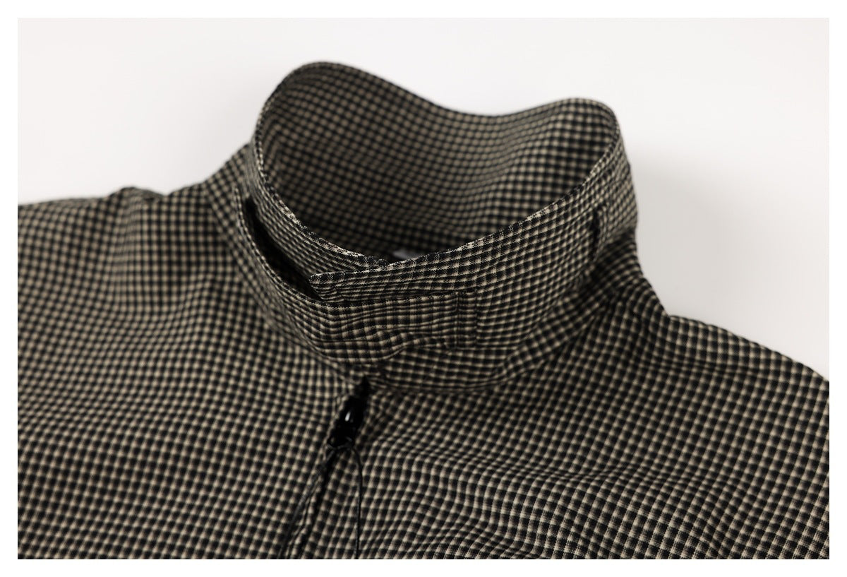 Close-up of the standing collar and upper zipper of a black and beige small-check garment.