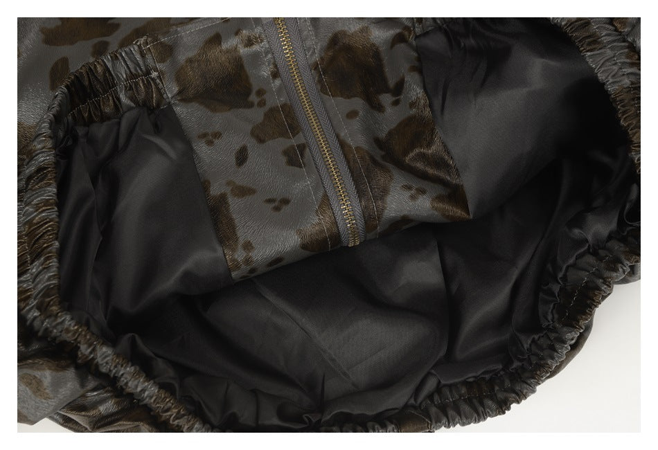 Close-up of the dark lining and zipper inside a gray-brown spotted garment.