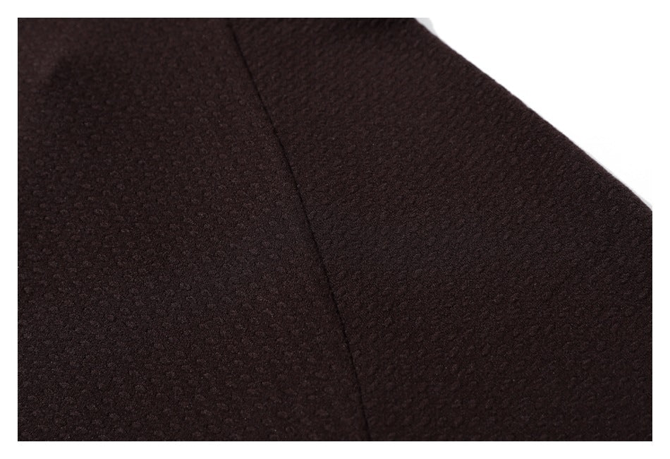 Close-up of dark brown textured fabric with a curved seam.
