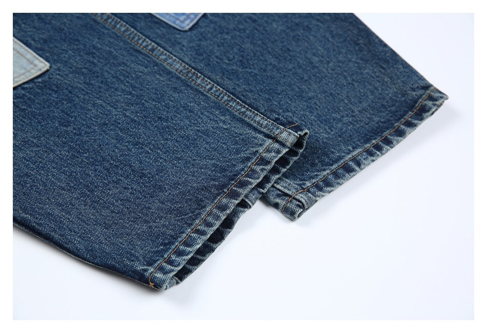 Close-up of dark blue jeans with folded, stitched hems against a white background.